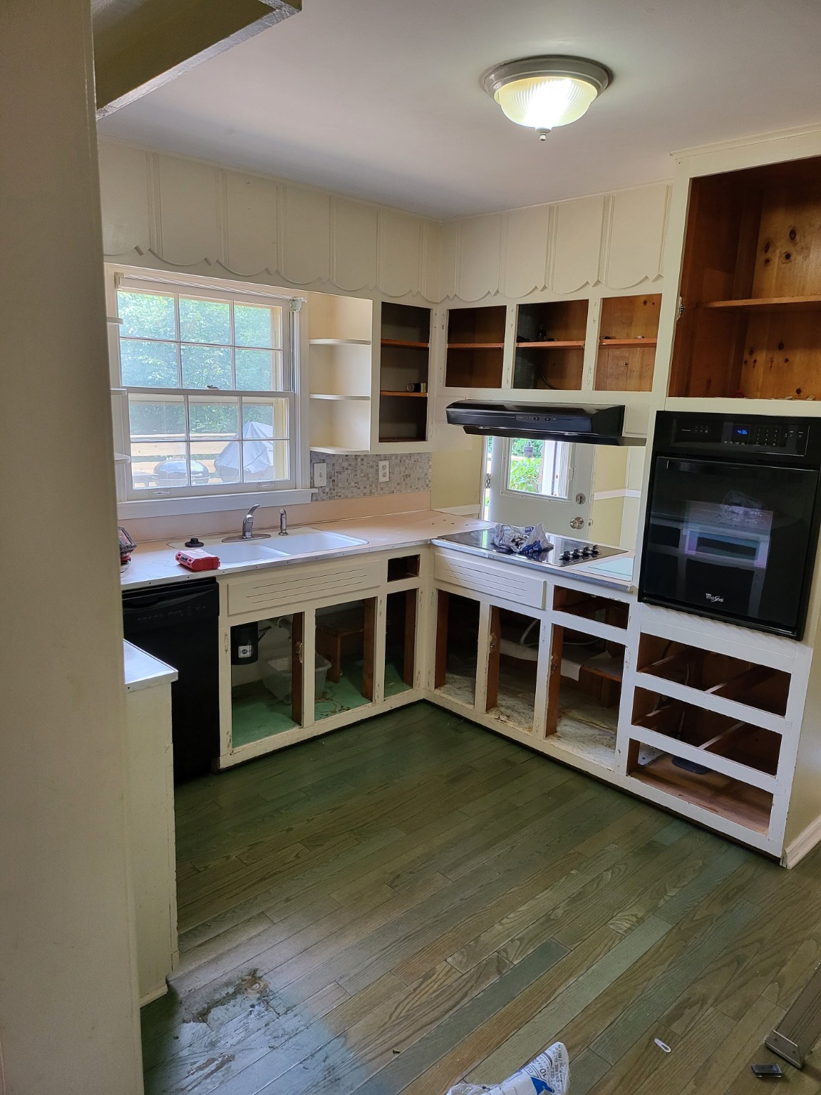 Original kitchen with older cabinets and green flooring