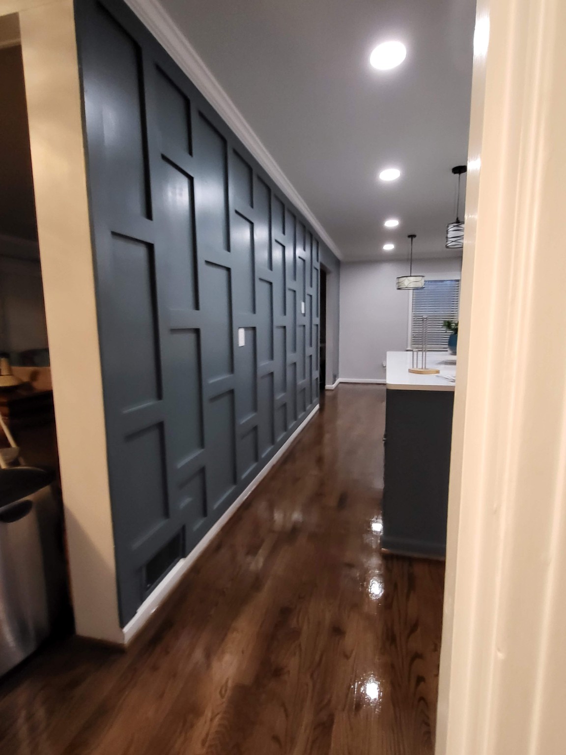 Finished blue paneled feature wall beside the kitchen island