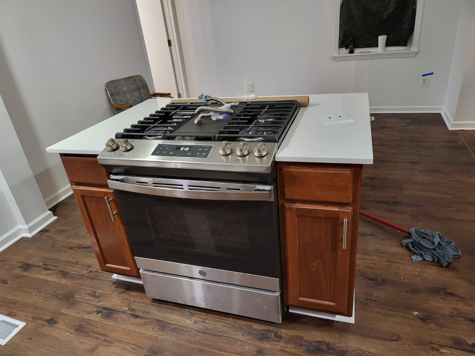 Stainless range in the wood cabinet kitchen island during installation