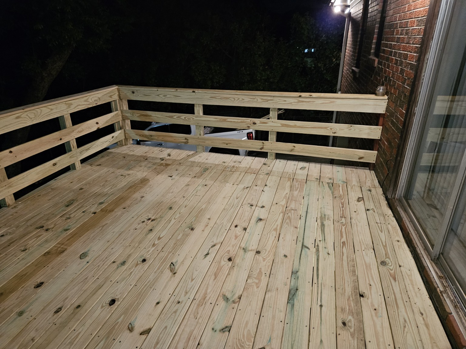 New wood deck with railings viewed at night