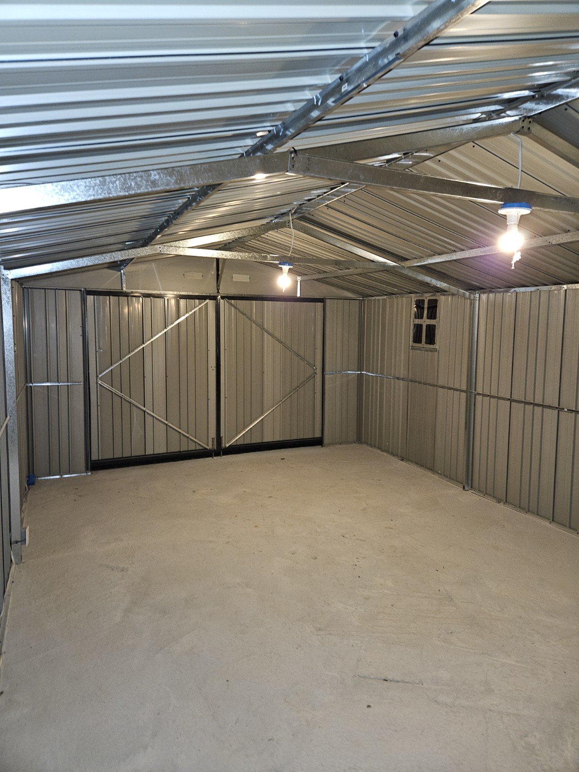 Finished outbuilding interior with concrete floor and overhead lighting