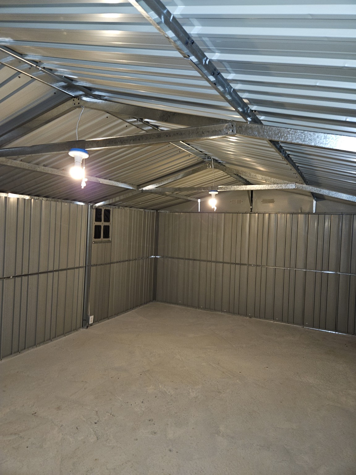 Finished outbuilding interior showing roof framing and lighting