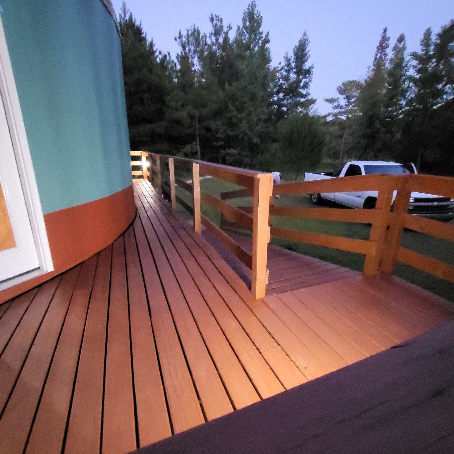 Finished deck boards and railings alongside the yurt